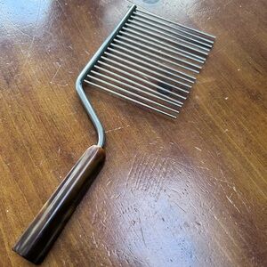 Vintage cake slicer with a swirled bakelite handle and metal tines.preloved